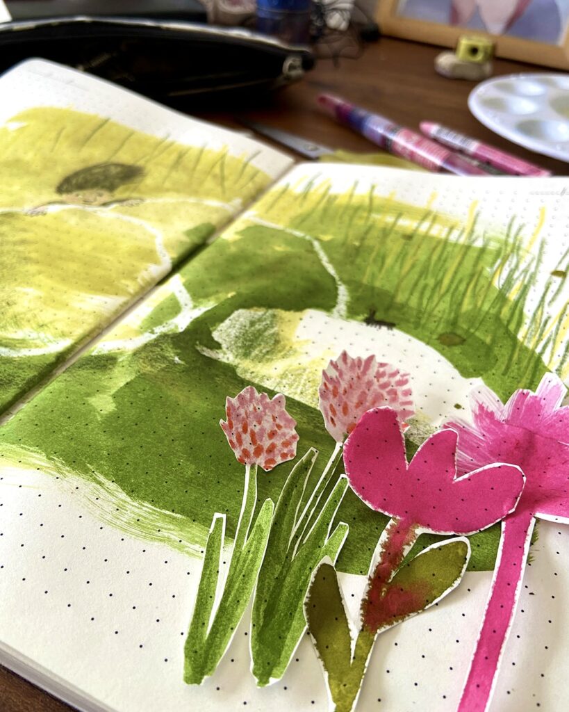 Photograph of pink flowers cut out in paper and pasted in a sketchbook.